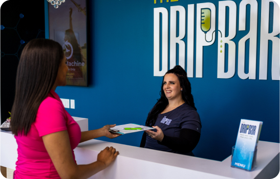 Woman handing form to front desk