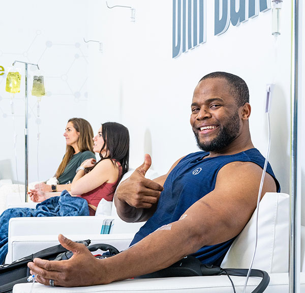 man sitting in chair smiling dripbar iv treatment